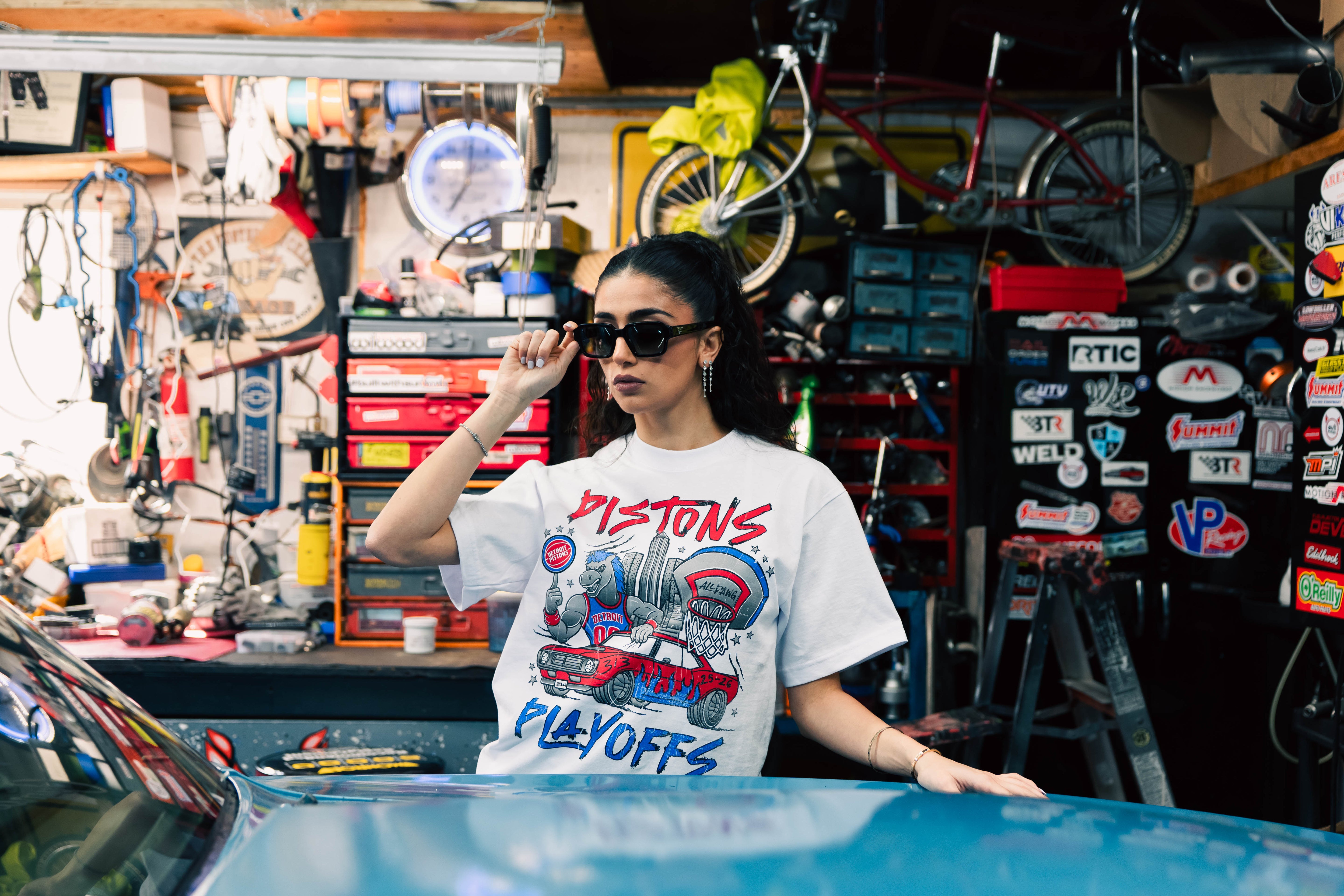 Juliana Rabban posing in her Just by Juliana Detroit Pistons playoff shirt designed for the Round 2 collaboration at Little Caesars Arena.