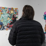 Visitors viewing original canvas artwork created by Just by Juliana at art display